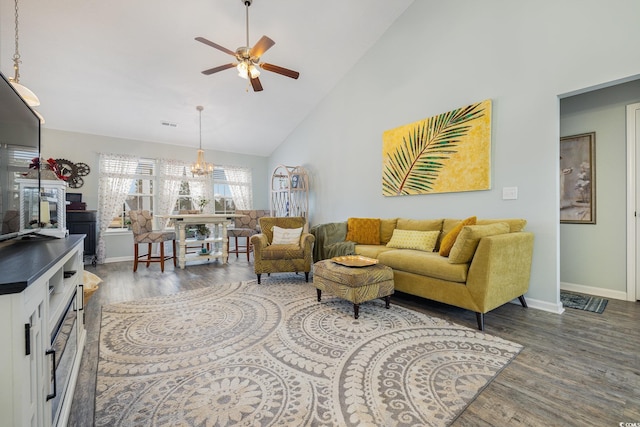 living room with ceiling fan with notable chandelier, dark hardwood / wood-style floors, and high vaulted ceiling