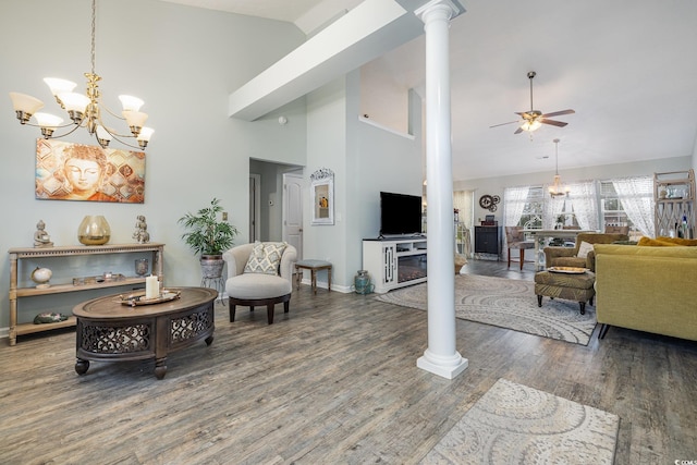 living room featuring ornate columns, a towering ceiling, dark hardwood / wood-style floors, and ceiling fan with notable chandelier