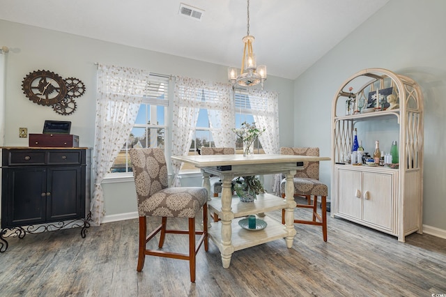 dining area with vaulted ceiling, a chandelier, and dark hardwood / wood-style floors