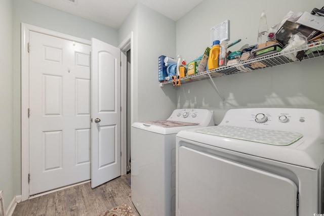 laundry area with light hardwood / wood-style floors and independent washer and dryer