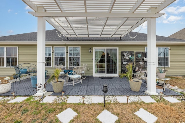 rear view of property featuring a pergola and a patio