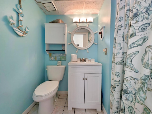 bathroom featuring tile patterned flooring, vanity, toilet, and walk in shower