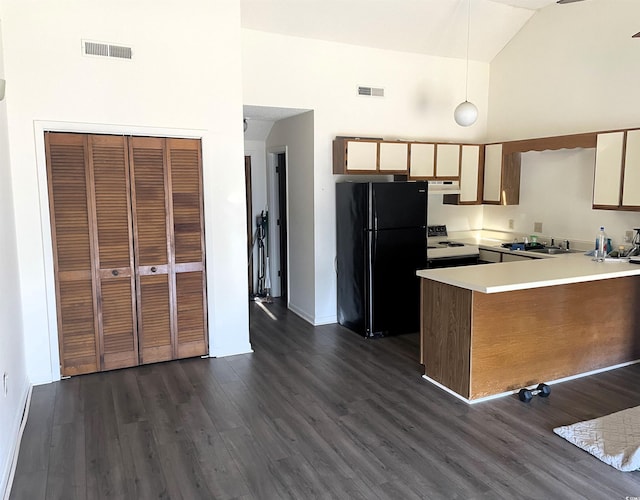 kitchen with hanging light fixtures, high vaulted ceiling, black fridge, white electric stove, and kitchen peninsula