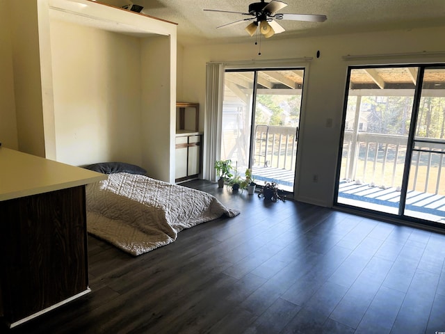 bedroom with dark wood-type flooring, ceiling fan, access to exterior, and a textured ceiling