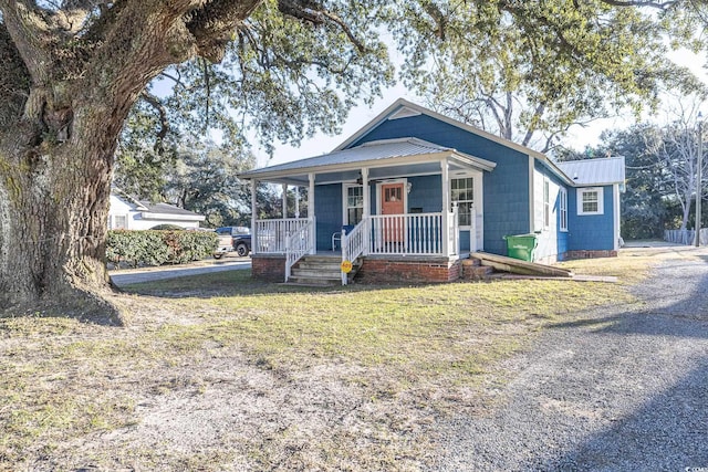 bungalow with a front yard and covered porch