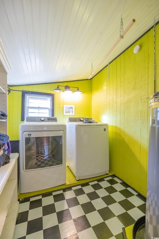 laundry room featuring wood walls and washing machine and dryer