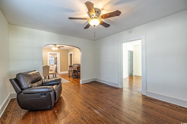 living area with ceiling fan and dark hardwood / wood-style flooring