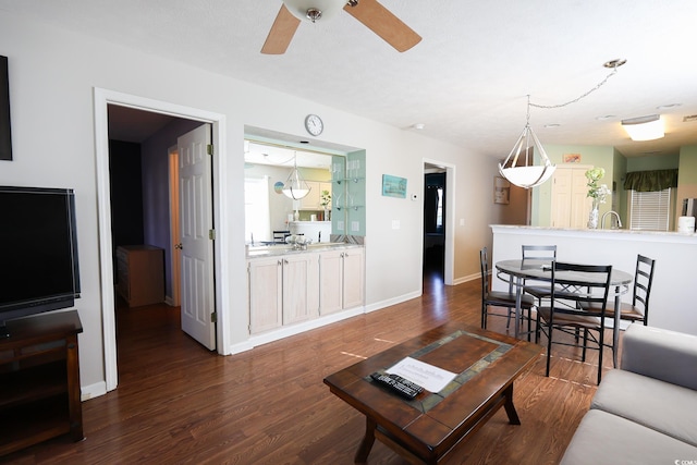 living room featuring ceiling fan and dark hardwood / wood-style flooring