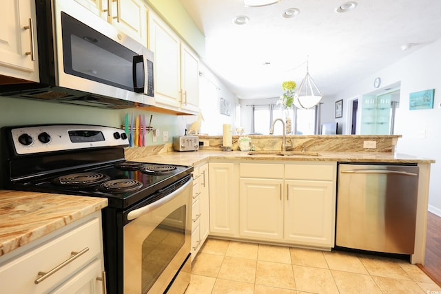 kitchen with light tile patterned floors, white cabinetry, sink, and appliances with stainless steel finishes