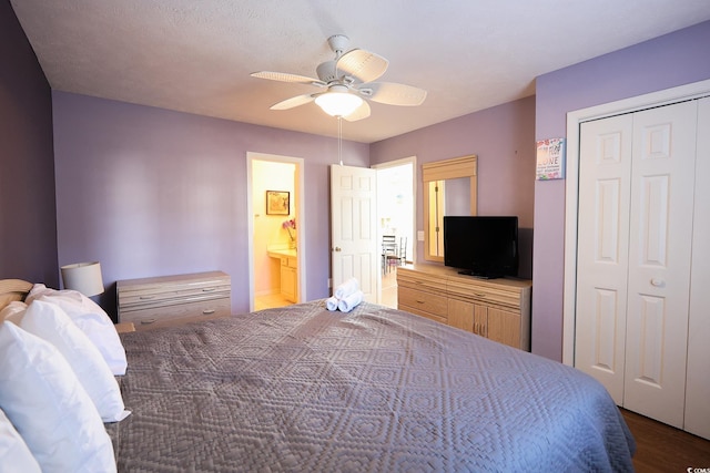 bedroom featuring a closet, ensuite bathroom, ceiling fan, and dark wood-type flooring