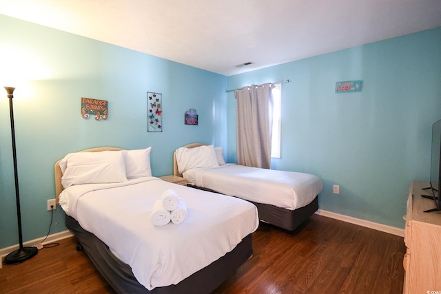 bedroom with dark hardwood / wood-style floors