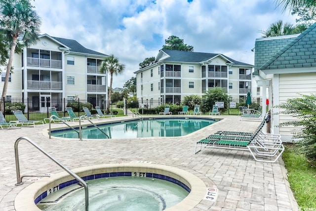 view of swimming pool featuring a patio area and a hot tub