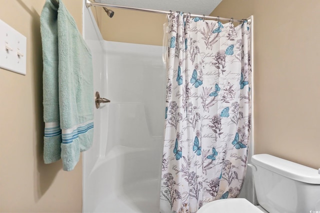 bathroom with toilet and a shower with shower curtain