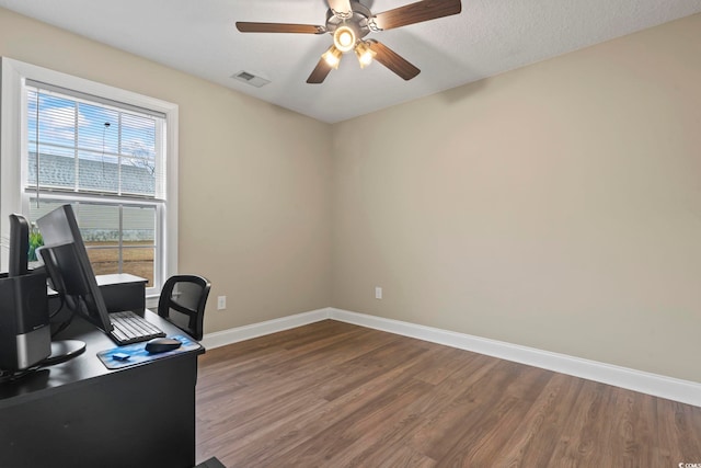 office area with ceiling fan, dark hardwood / wood-style flooring, and a textured ceiling