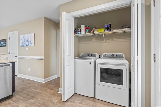 laundry area with washer and clothes dryer and light wood-type flooring