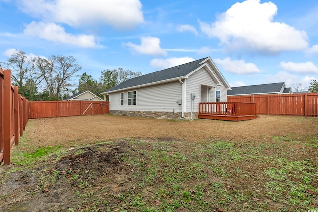 back of house with a wooden deck and a yard