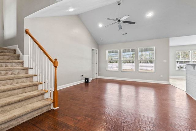 unfurnished living room with dark hardwood / wood-style flooring, high vaulted ceiling, plenty of natural light, and ceiling fan