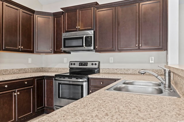 kitchen featuring dark brown cabinets, stainless steel appliances, and sink