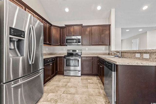 kitchen featuring lofted ceiling, sink, light stone countertops, appliances with stainless steel finishes, and dark brown cabinetry