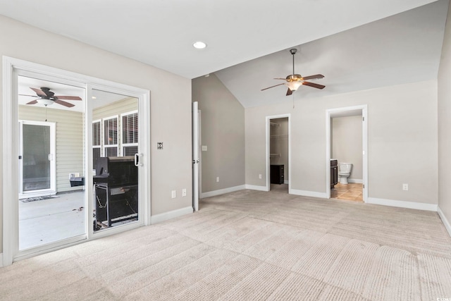 empty room featuring light carpet, ceiling fan, and lofted ceiling