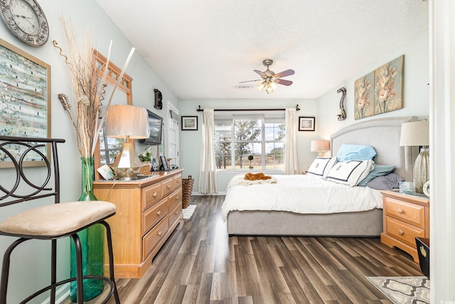 bedroom featuring a textured ceiling, dark hardwood / wood-style floors, and ceiling fan