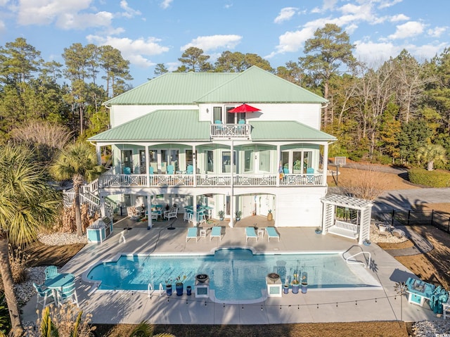 rear view of house with a patio and a balcony