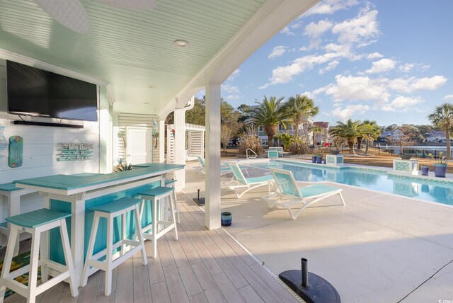 view of pool featuring exterior bar, a patio, and ceiling fan