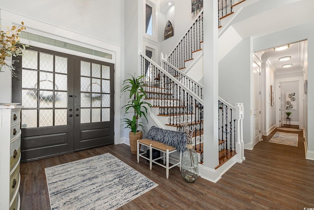 entryway with french doors, dark hardwood / wood-style flooring, ornamental molding, and a high ceiling