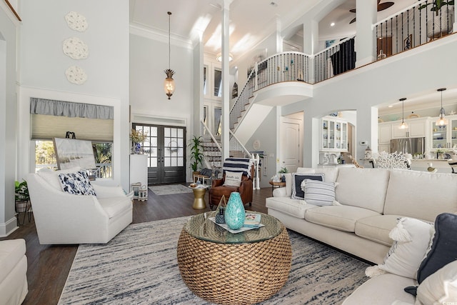 living room with french doors, a towering ceiling, dark hardwood / wood-style flooring, and a wealth of natural light