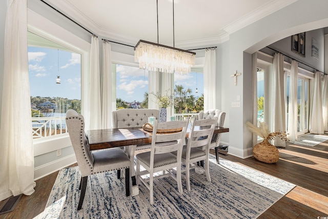 dining space with crown molding, dark hardwood / wood-style flooring, and a chandelier