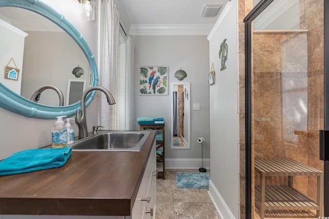 bathroom with a tile shower, vanity, and ornamental molding