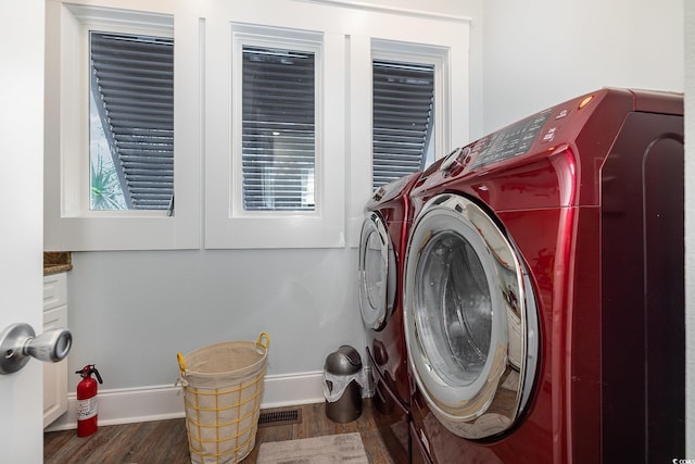 laundry area featuring dark hardwood / wood-style flooring and washing machine and clothes dryer