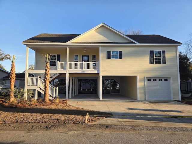 coastal home with a carport, a garage, and covered porch