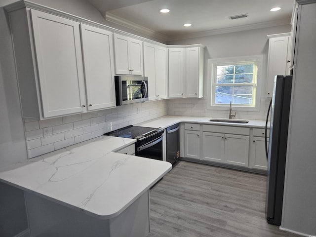 kitchen with white cabinetry, sink, light stone counters, kitchen peninsula, and stainless steel appliances