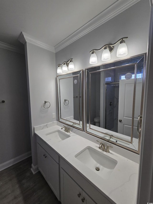 bathroom with vanity, crown molding, a shower with door, and toilet