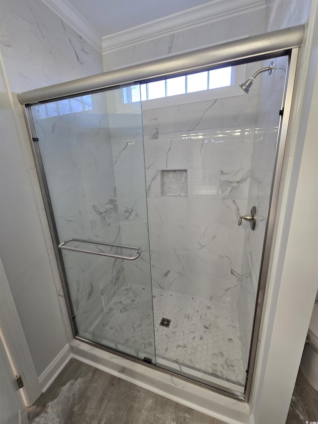 bathroom featuring crown molding, wood-type flooring, and a shower with shower door