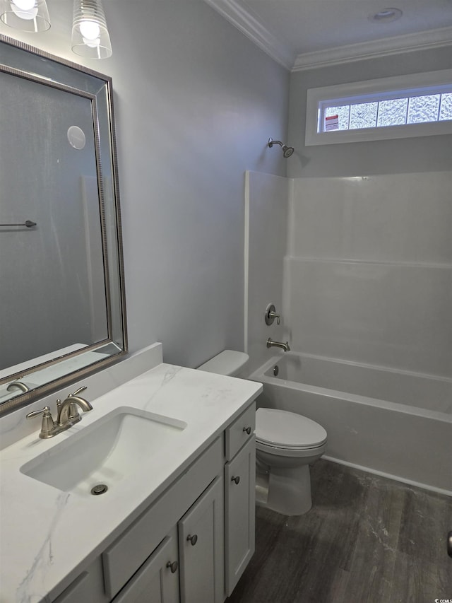 full bathroom with toilet, bathing tub / shower combination, ornamental molding, vanity, and hardwood / wood-style flooring