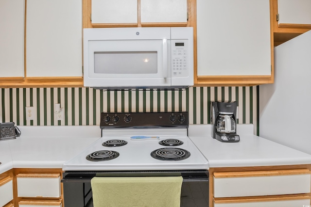 kitchen featuring white cabinetry and white appliances