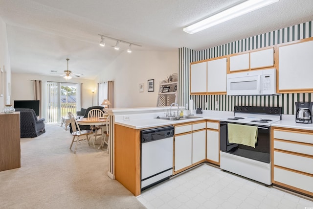 kitchen featuring white cabinets, kitchen peninsula, white appliances, and sink