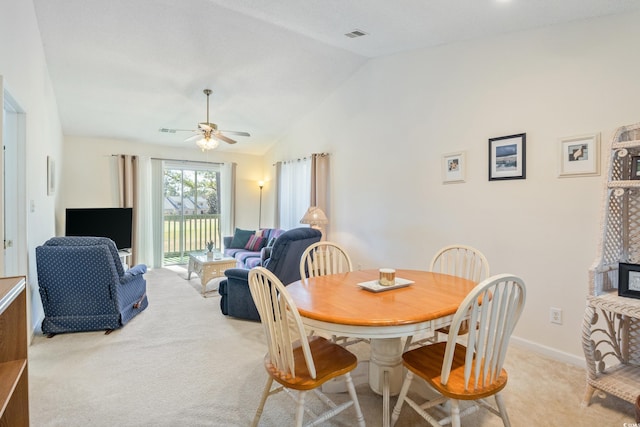 carpeted dining area with ceiling fan and lofted ceiling