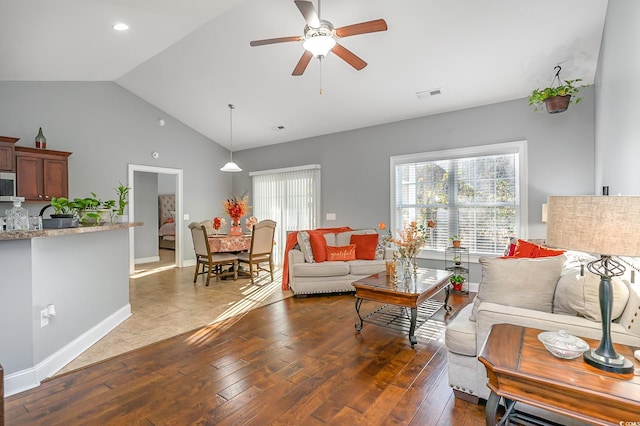 living room with ceiling fan, dark wood-type flooring, and lofted ceiling