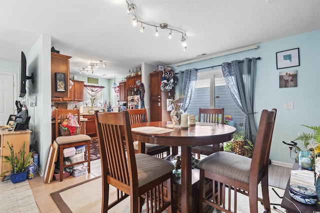 dining space with light tile patterned floors and a textured ceiling