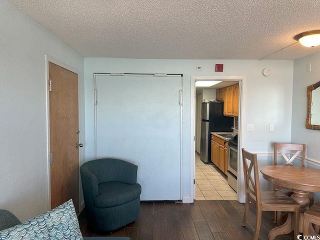 kitchen featuring a textured ceiling, appliances with stainless steel finishes, and light hardwood / wood-style flooring