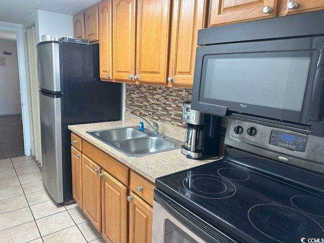 kitchen with stainless steel refrigerator, sink, black electric range oven, decorative backsplash, and light tile patterned flooring