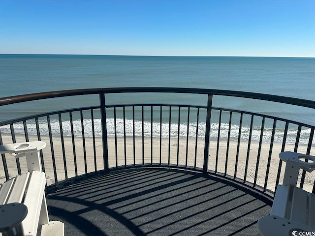 balcony featuring a view of the beach and a water view