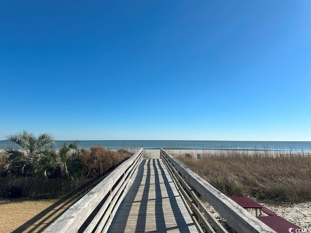 surrounding community with a water view and a beach view