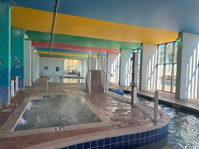 view of pool with an indoor hot tub