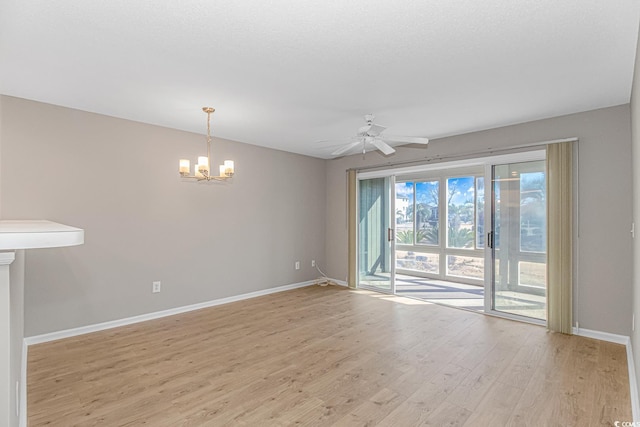 spare room with light hardwood / wood-style flooring and ceiling fan with notable chandelier