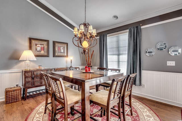 dining space featuring ornamental molding, hardwood / wood-style floors, and an inviting chandelier