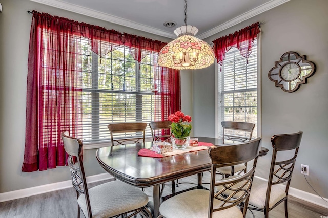 dining space with hardwood / wood-style flooring and ornamental molding